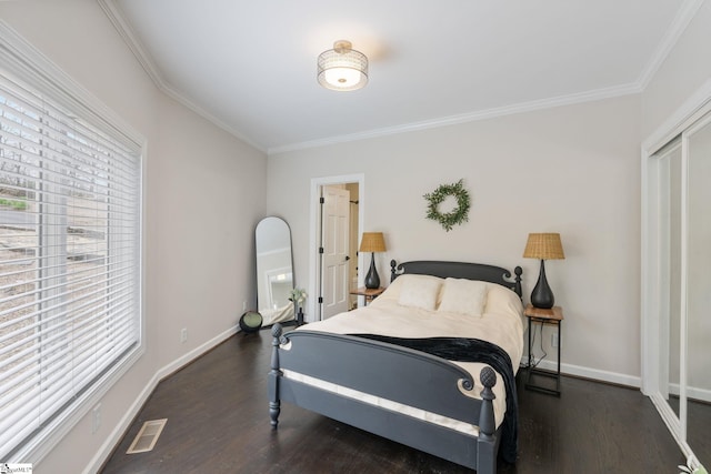 bedroom featuring crown molding, dark wood-type flooring, and a closet