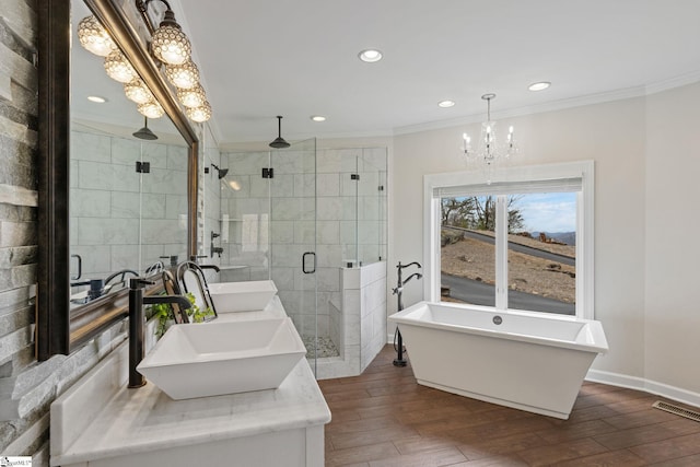 bathroom with hardwood / wood-style floors, vanity, an inviting chandelier, crown molding, and independent shower and bath