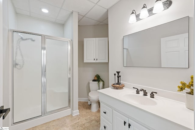 bathroom featuring tile patterned flooring, an enclosed shower, toilet, a paneled ceiling, and vanity