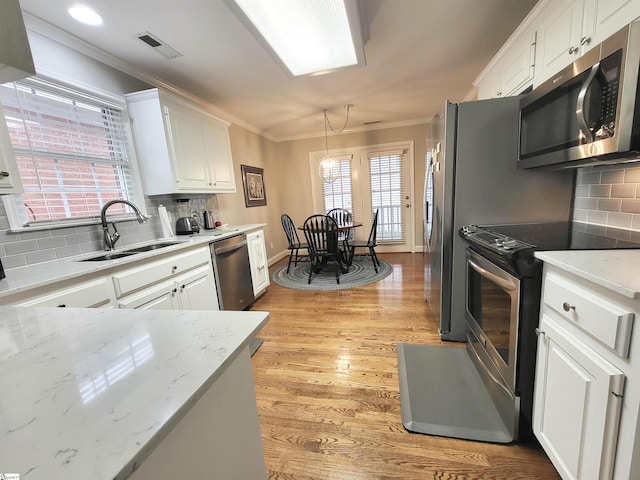 kitchen with plenty of natural light, white cabinets, and stainless steel appliances