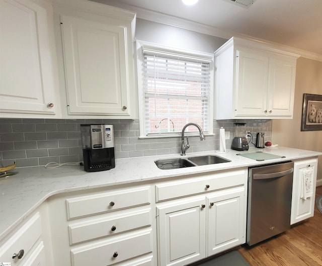 kitchen with stainless steel dishwasher, crown molding, white cabinets, and sink