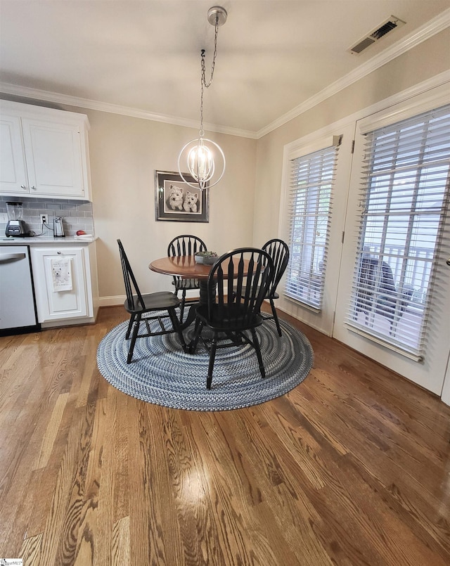 dining room with a chandelier, light hardwood / wood-style floors, and ornamental molding