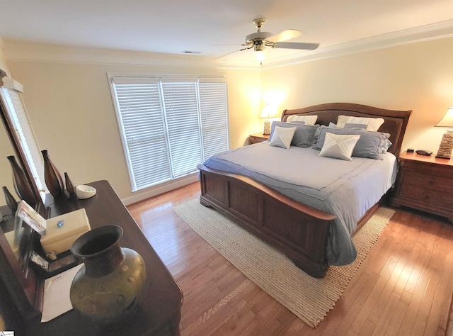 bedroom featuring light hardwood / wood-style floors, ceiling fan, and ornamental molding