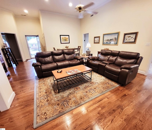 living room with wood-type flooring, ceiling fan, and crown molding