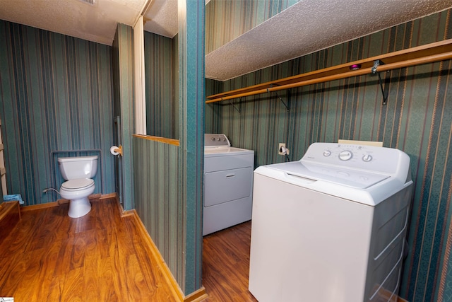 laundry area with hardwood / wood-style flooring, washer and dryer, and a textured ceiling