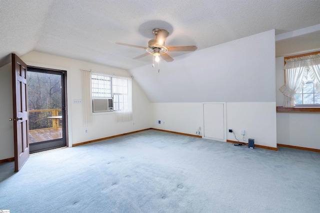 bonus room with light carpet, a textured ceiling, vaulted ceiling, and ceiling fan