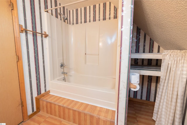 bathroom featuring wood-type flooring and shower / tub combo