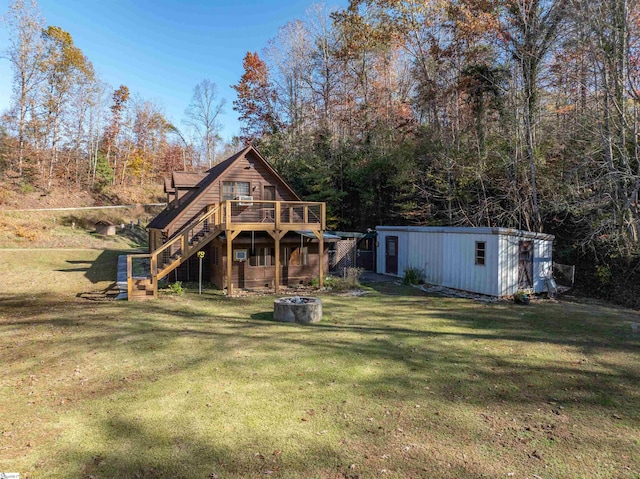 back of house with a lawn, a deck, and a storage shed