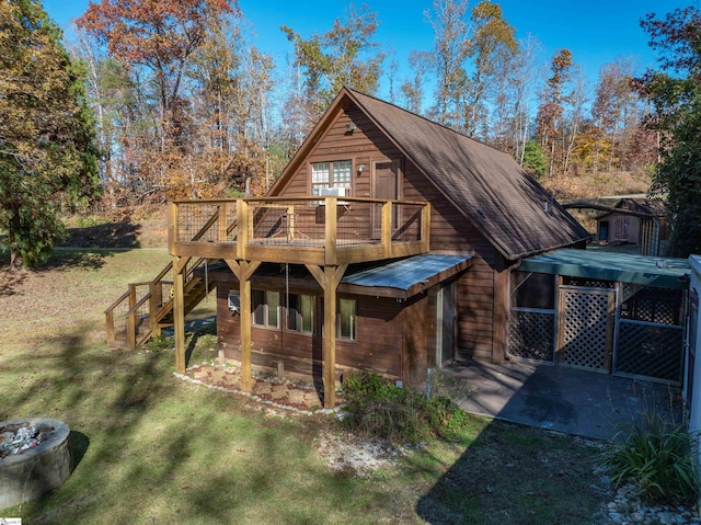 rear view of property with a patio, a yard, and a deck