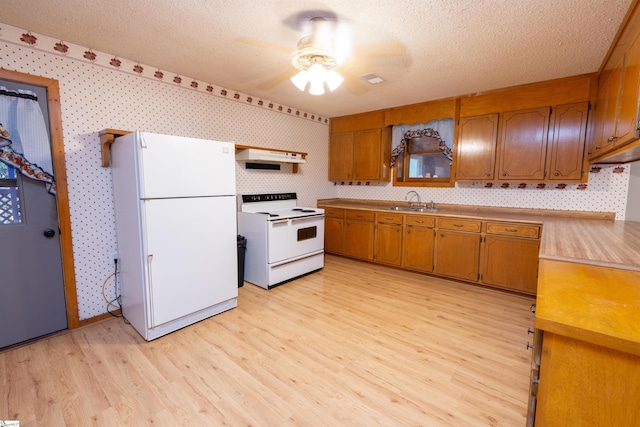 kitchen featuring sink, extractor fan, a textured ceiling, white appliances, and light wood-type flooring