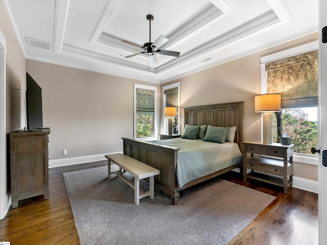 bedroom with a tray ceiling, ceiling fan, dark hardwood / wood-style flooring, and ornamental molding