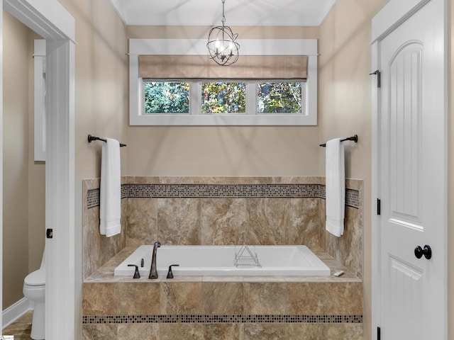 bathroom featuring a chandelier, a relaxing tiled tub, and plenty of natural light