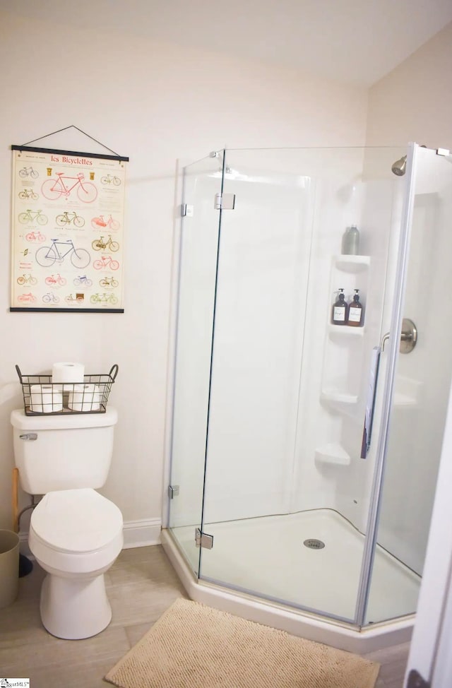 bathroom with toilet and a shower with shower door