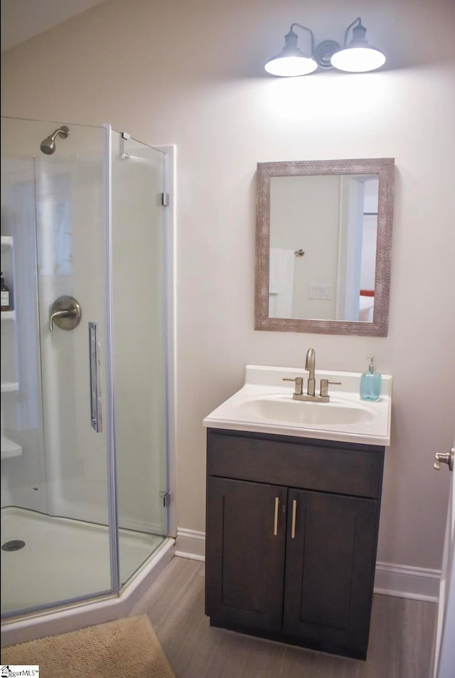 bathroom featuring hardwood / wood-style flooring, vanity, walk in shower, and vaulted ceiling