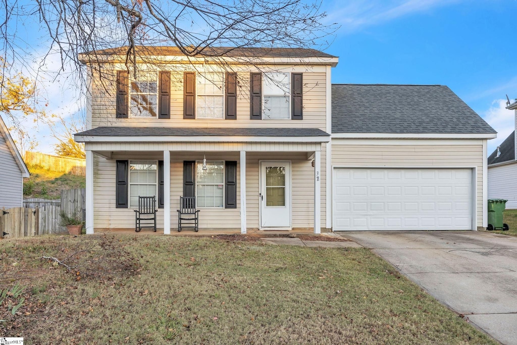 view of front property featuring covered porch, a garage, and a front lawn