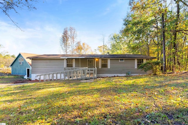 ranch-style home featuring a wooden deck and a front yard