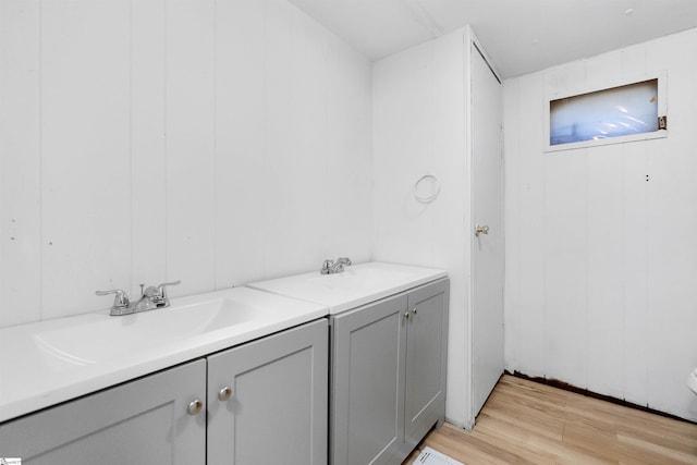 bathroom featuring vanity, wood-type flooring, and wooden walls