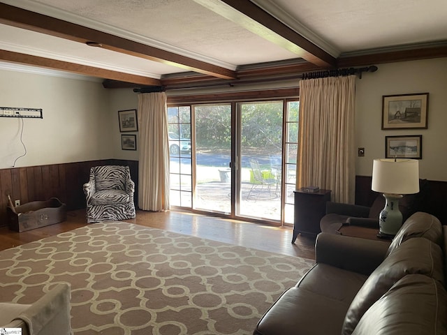 living room with beam ceiling, a textured ceiling, and ornamental molding