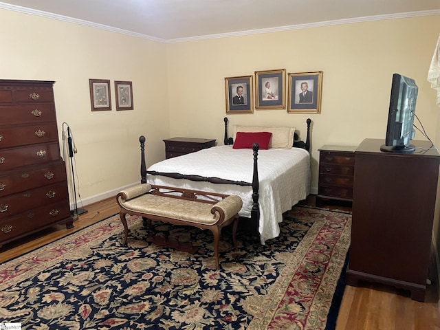 bedroom with hardwood / wood-style flooring and crown molding