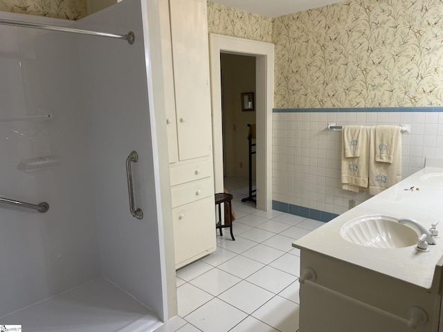 bathroom featuring tile patterned flooring, vanity, walk in shower, and tile walls