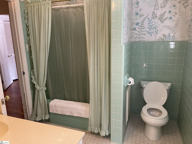 bathroom featuring vanity, tile patterned flooring, toilet, tile walls, and walk in shower