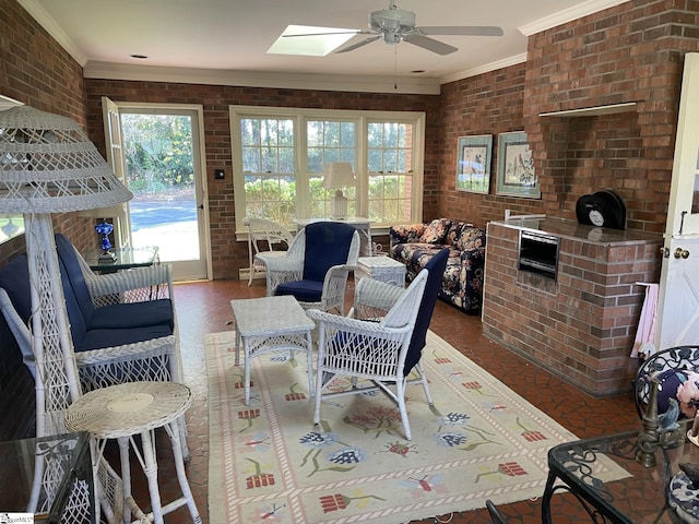 living room featuring ceiling fan, crown molding, brick wall, and a skylight