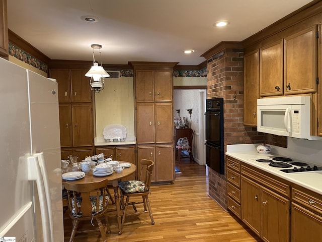 kitchen with light hardwood / wood-style flooring, decorative light fixtures, and white appliances