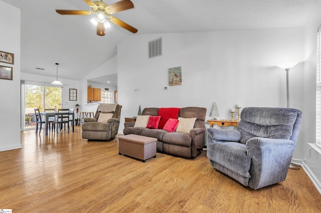 living room featuring light hardwood / wood-style floors, high vaulted ceiling, and ceiling fan