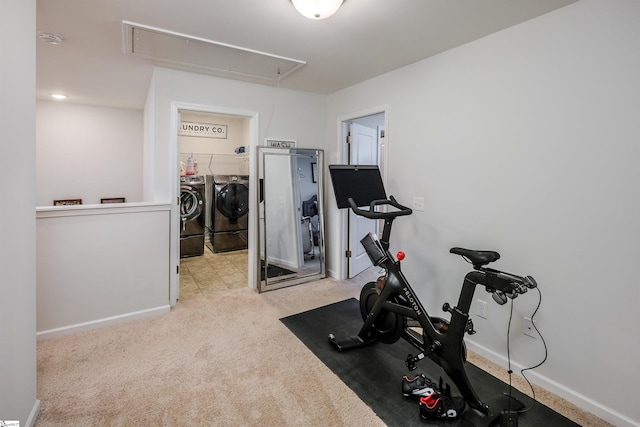 exercise room featuring washer and clothes dryer and light colored carpet