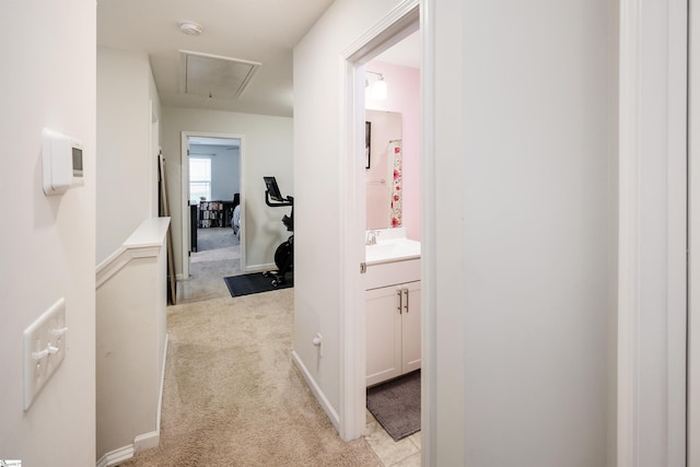 corridor with light carpet and sink