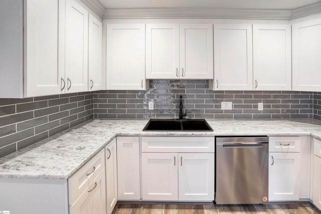 kitchen with hardwood / wood-style floors, sink, stainless steel dishwasher, decorative backsplash, and white cabinetry