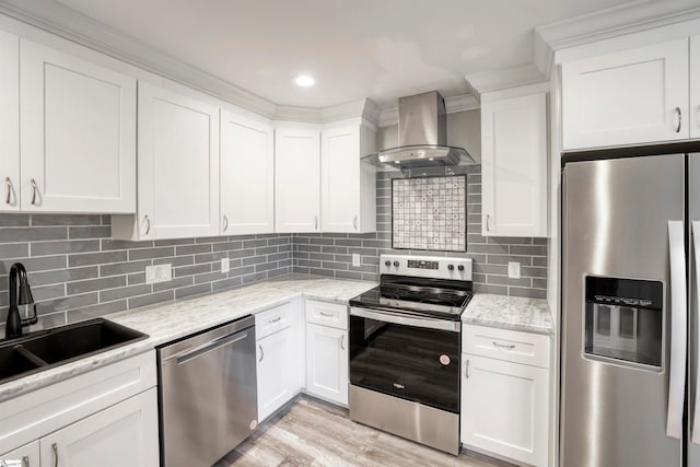 kitchen with light stone counters, stainless steel appliances, white cabinetry, and wall chimney range hood