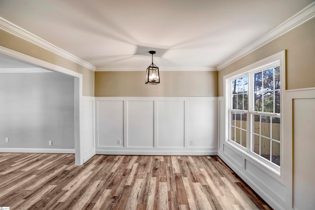 unfurnished dining area with ornamental molding and light wood-type flooring