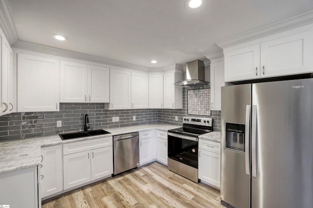 kitchen with white cabinets, appliances with stainless steel finishes, sink, and wall chimney range hood