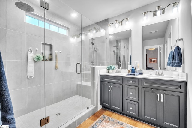 bathroom with hardwood / wood-style floors, vanity, and walk in shower