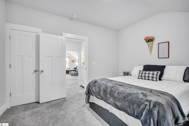 bedroom with carpet flooring and lofted ceiling