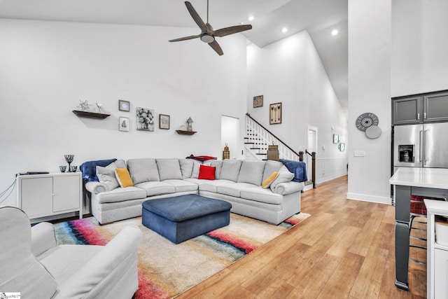 living room with wood-type flooring, high vaulted ceiling, and ceiling fan