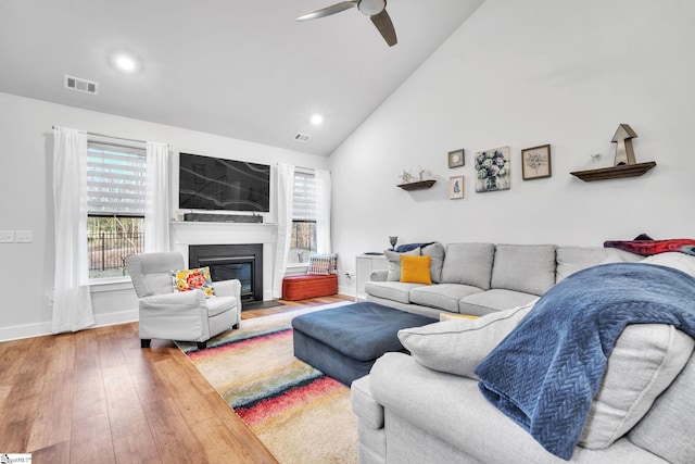 living room with ceiling fan, hardwood / wood-style floors, and vaulted ceiling