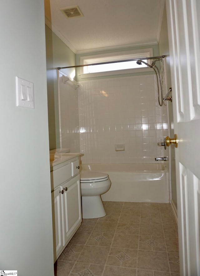 full bathroom with tile patterned flooring, crown molding, toilet, vanity, and tiled shower / bath