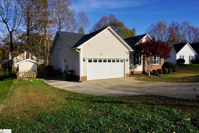 view of side of home with a storage shed, a yard, and a garage