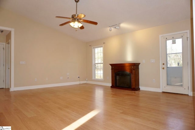 unfurnished living room featuring plenty of natural light, ceiling fan, lofted ceiling, and light hardwood / wood-style flooring