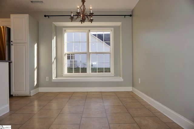 unfurnished dining area featuring a notable chandelier and light tile patterned floors