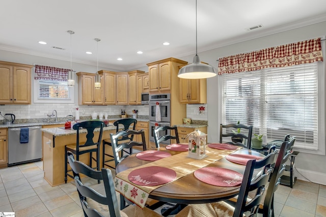 dining room with crown molding, sink, and light tile patterned floors