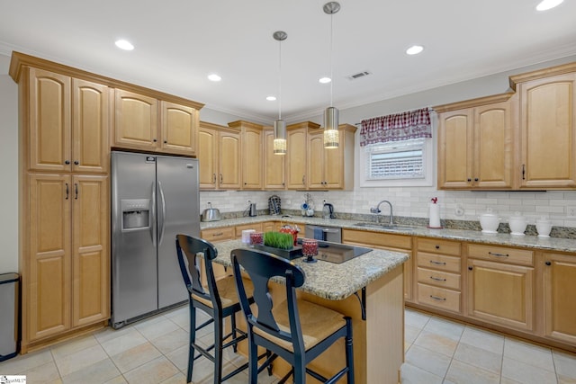 kitchen featuring appliances with stainless steel finishes, light stone counters, sink, pendant lighting, and a kitchen island