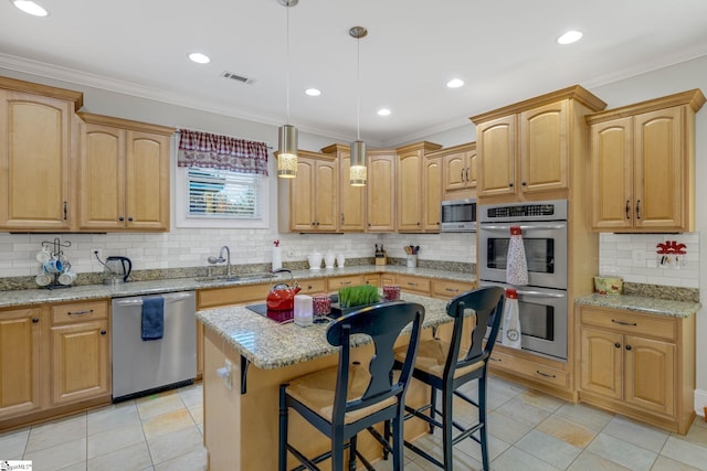 kitchen with sink, a center island, crown molding, pendant lighting, and appliances with stainless steel finishes