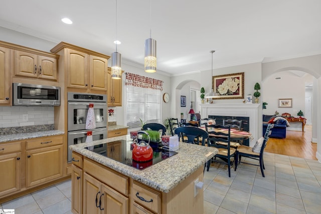 kitchen with stainless steel appliances, light stone counters, decorative light fixtures, light tile patterned floors, and ornamental molding