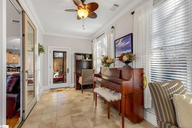 living area with light tile patterned floors, ceiling fan, and ornamental molding