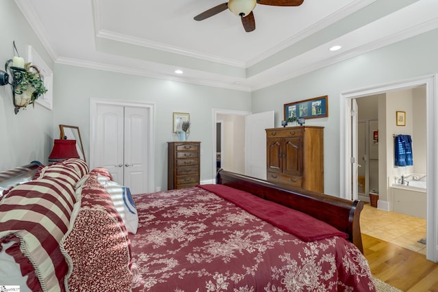 bedroom with crown molding, ceiling fan, connected bathroom, light hardwood / wood-style floors, and a closet