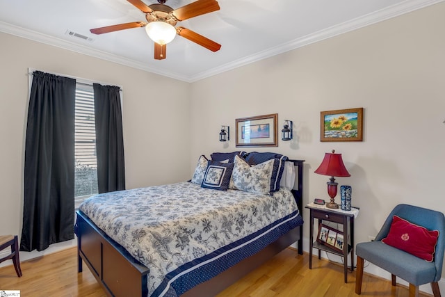 bedroom featuring ceiling fan, light hardwood / wood-style floors, and ornamental molding