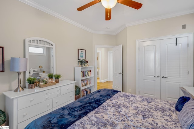 bedroom with ceiling fan, light wood-type flooring, crown molding, and a closet